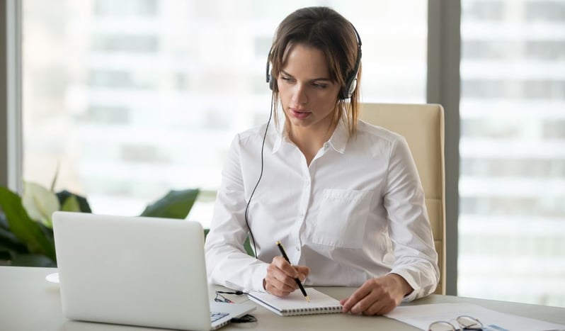 A professional on a video call taking notes