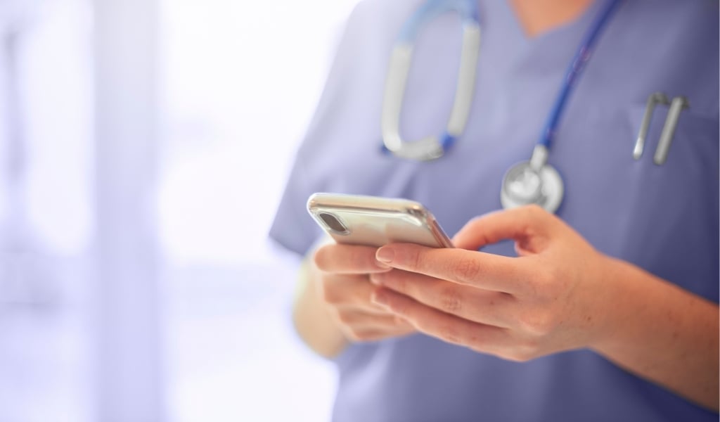 A healthcare practitioner holding a mobile phone