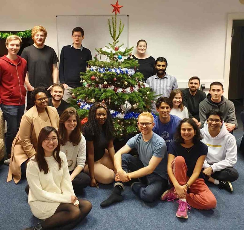 People around a christmas tree in office